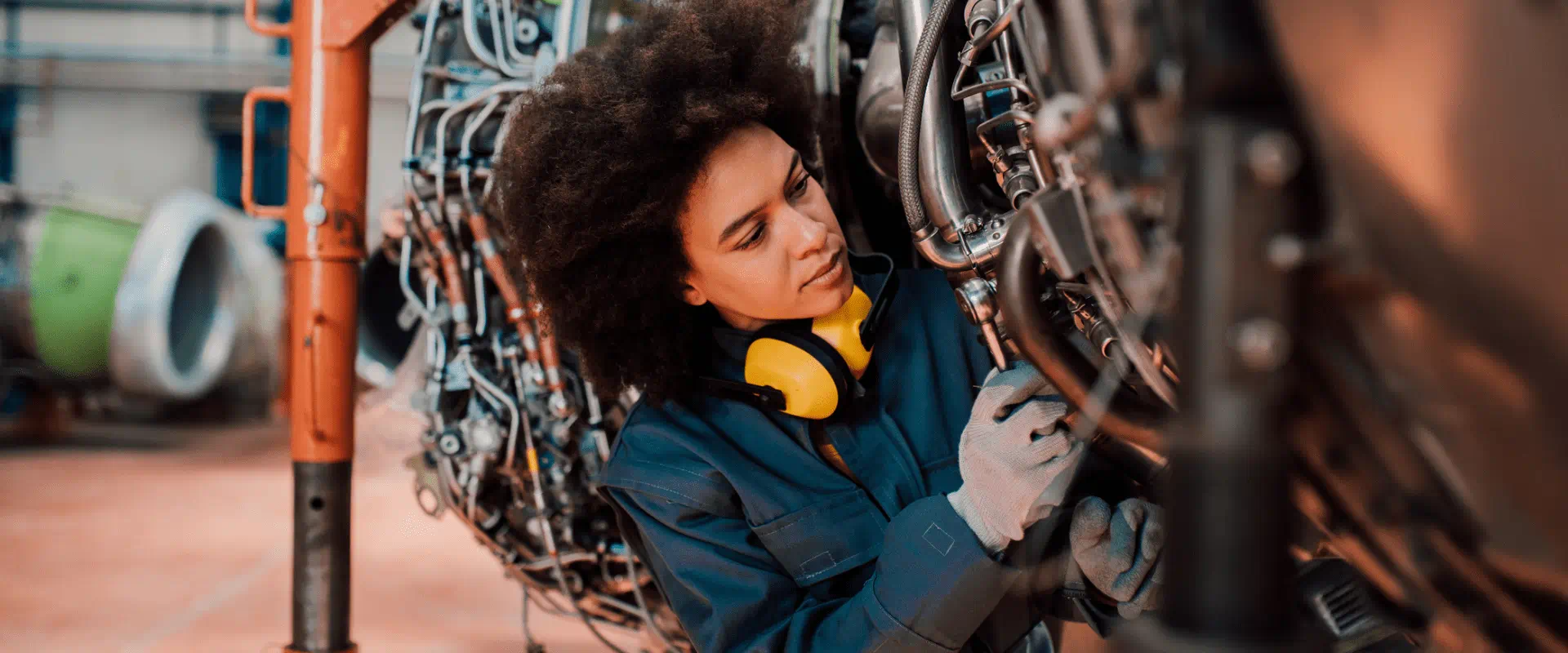 A worker fixes an engine A worker fixes an engine