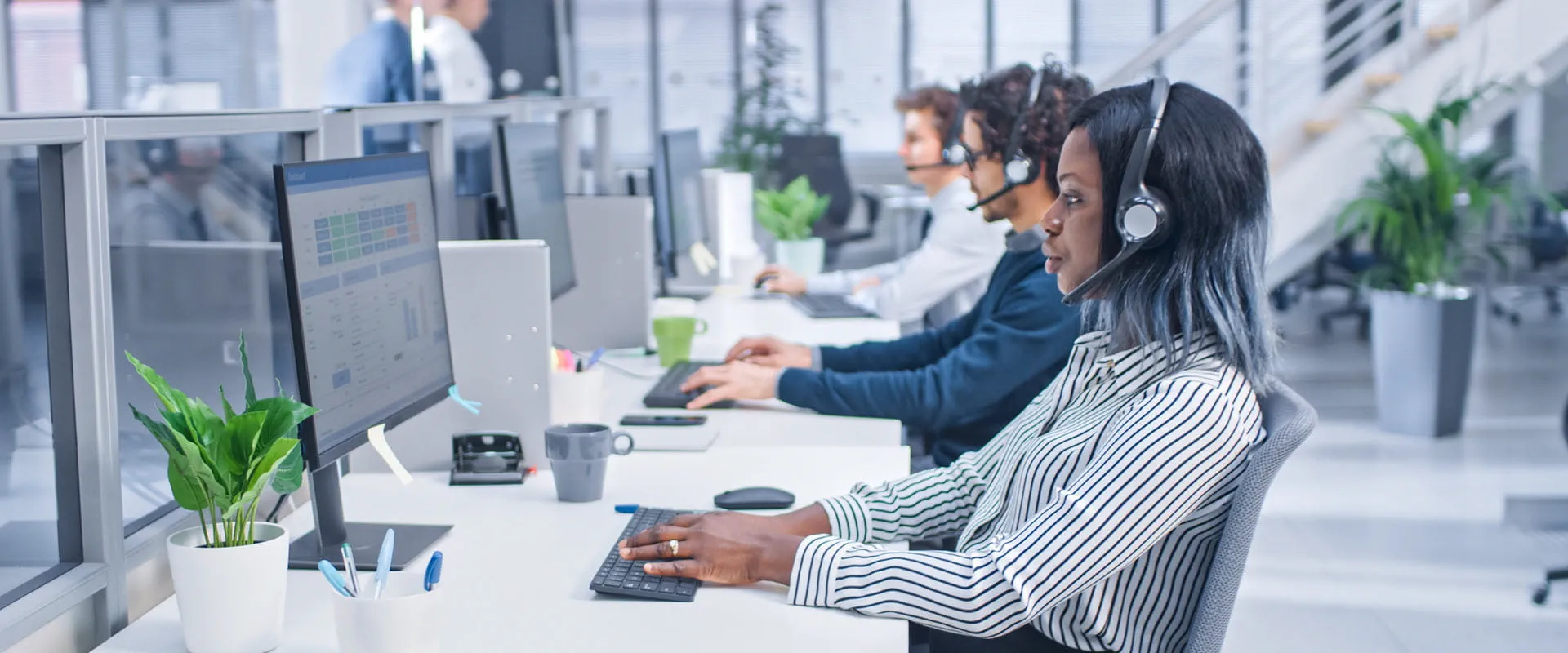 Team of customer service operators working at call center wearing headsets and actively taking calls. Team of customer service operators working at call center wearing headsets and actively taking calls.
