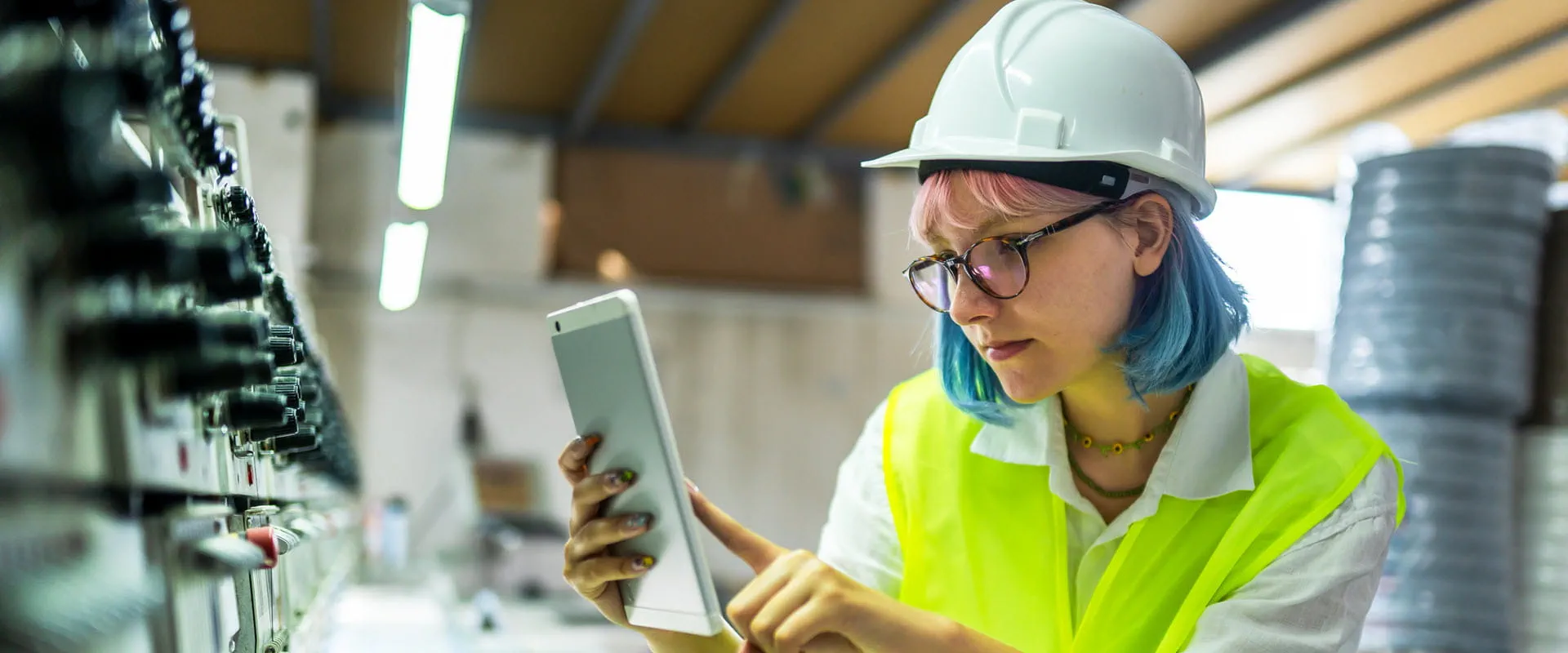 Young female engineer working with manufacturing equipment in a factory. Young female engineer working with manufacturing equipment in a factory.