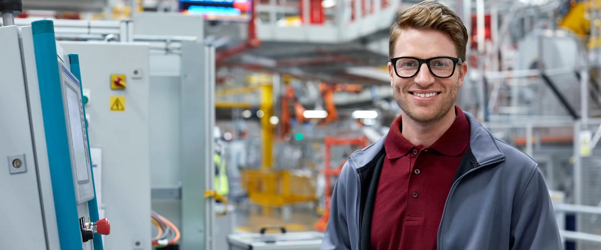 Portrait of mid adult engineer holding digital tablet by control panel at automobile industry.