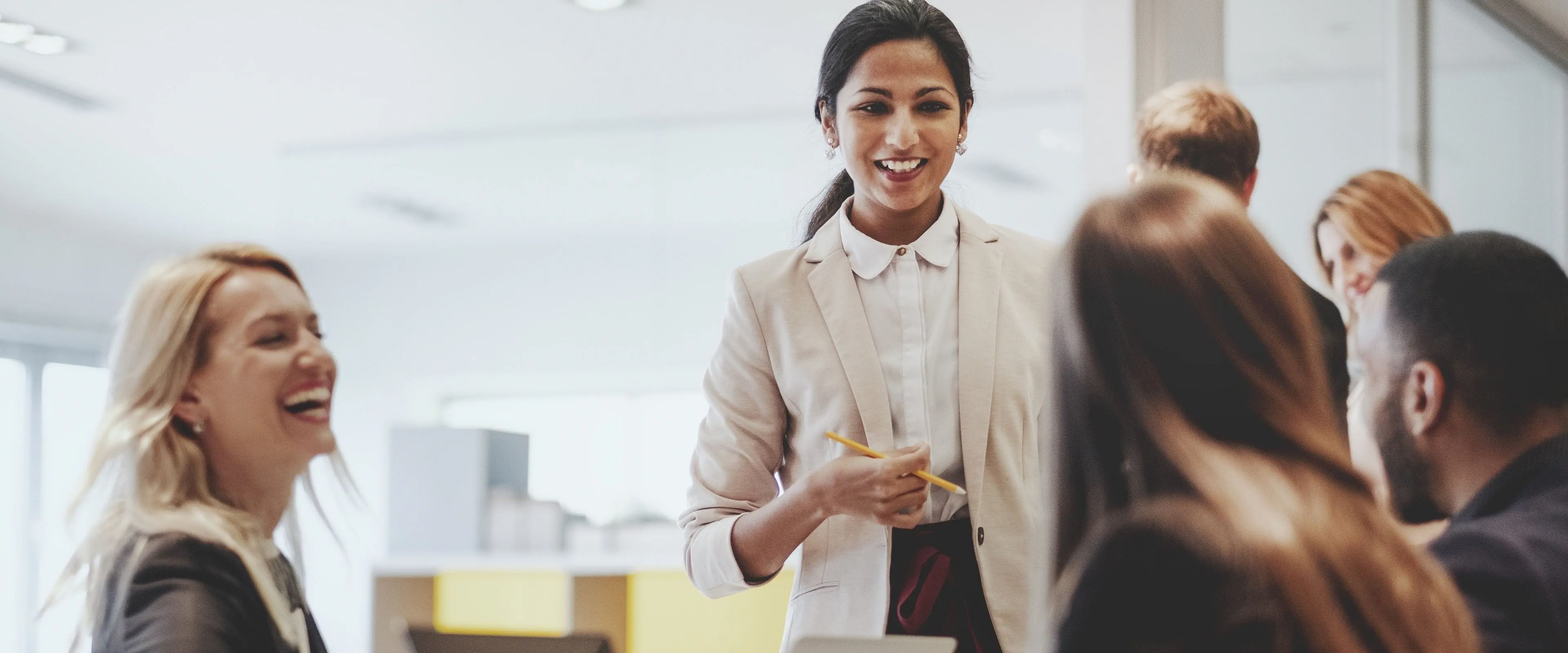 A group of professionally dressed office workers laugh together A group of professionally dressed office workers laugh together