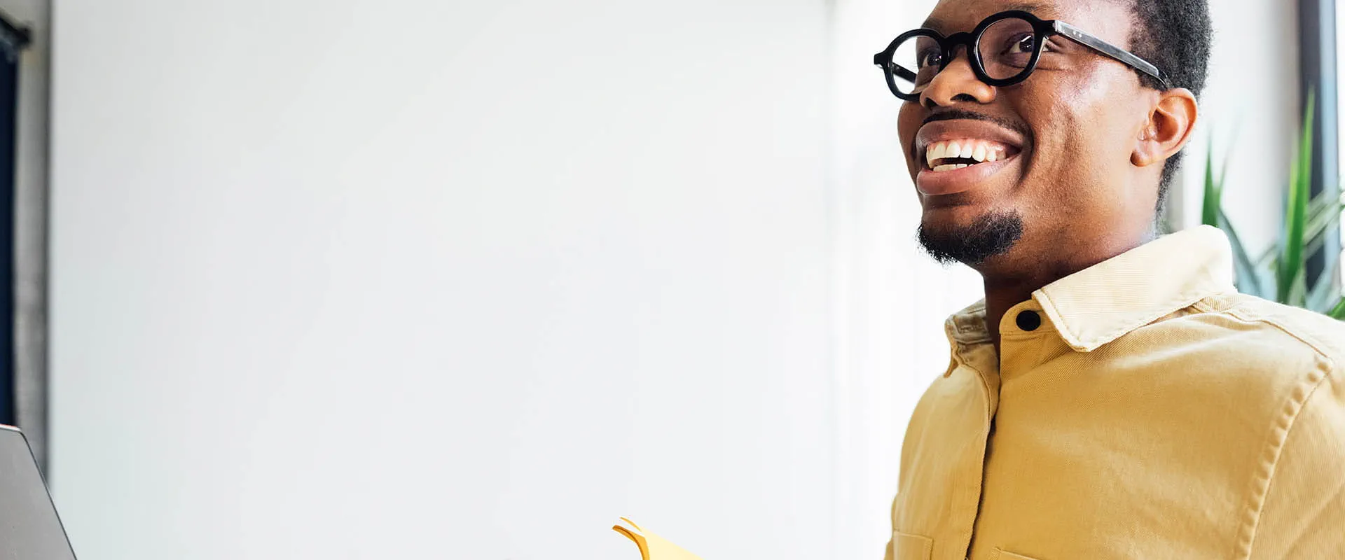 Man smiling while working in bright office space Man smiling while working in bright office space