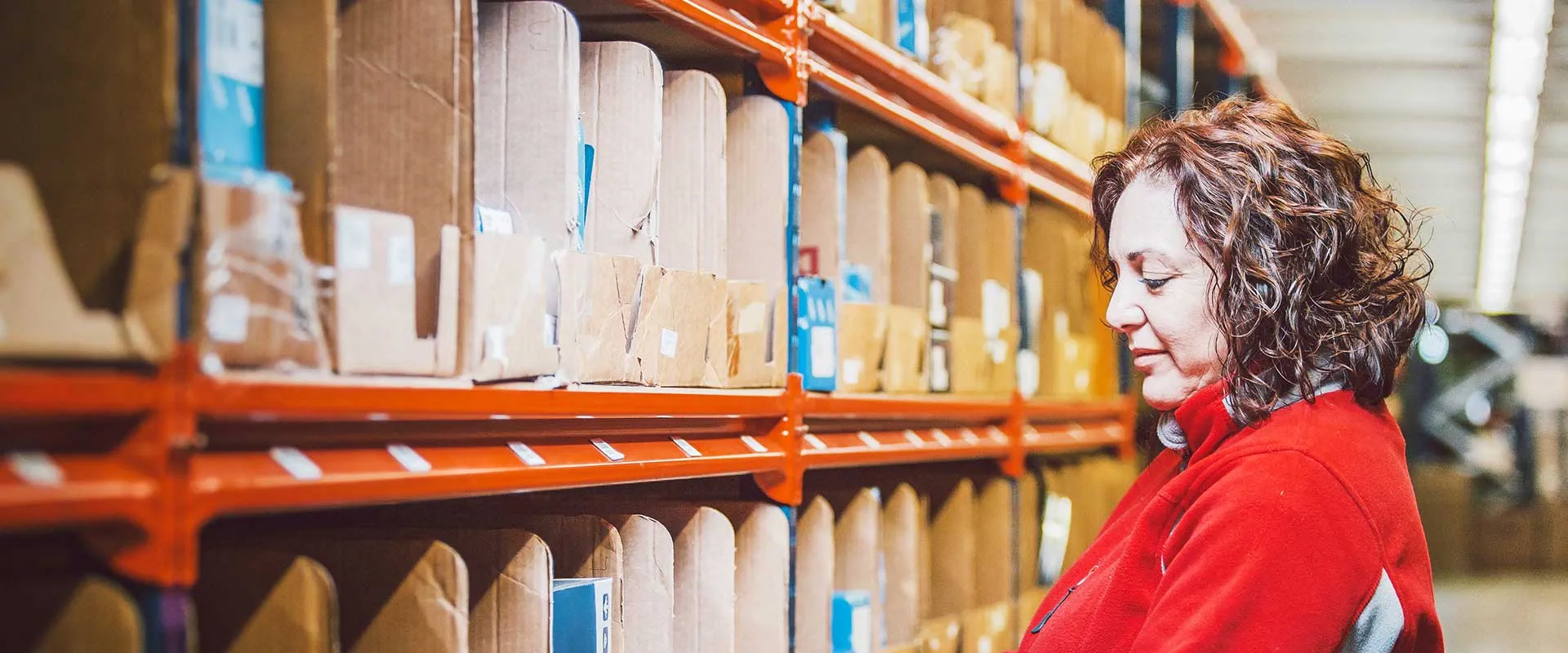Warehouse worker operating a pallet jack in a logistics environment Warehouse worker operating a pallet jack in a logistics environment