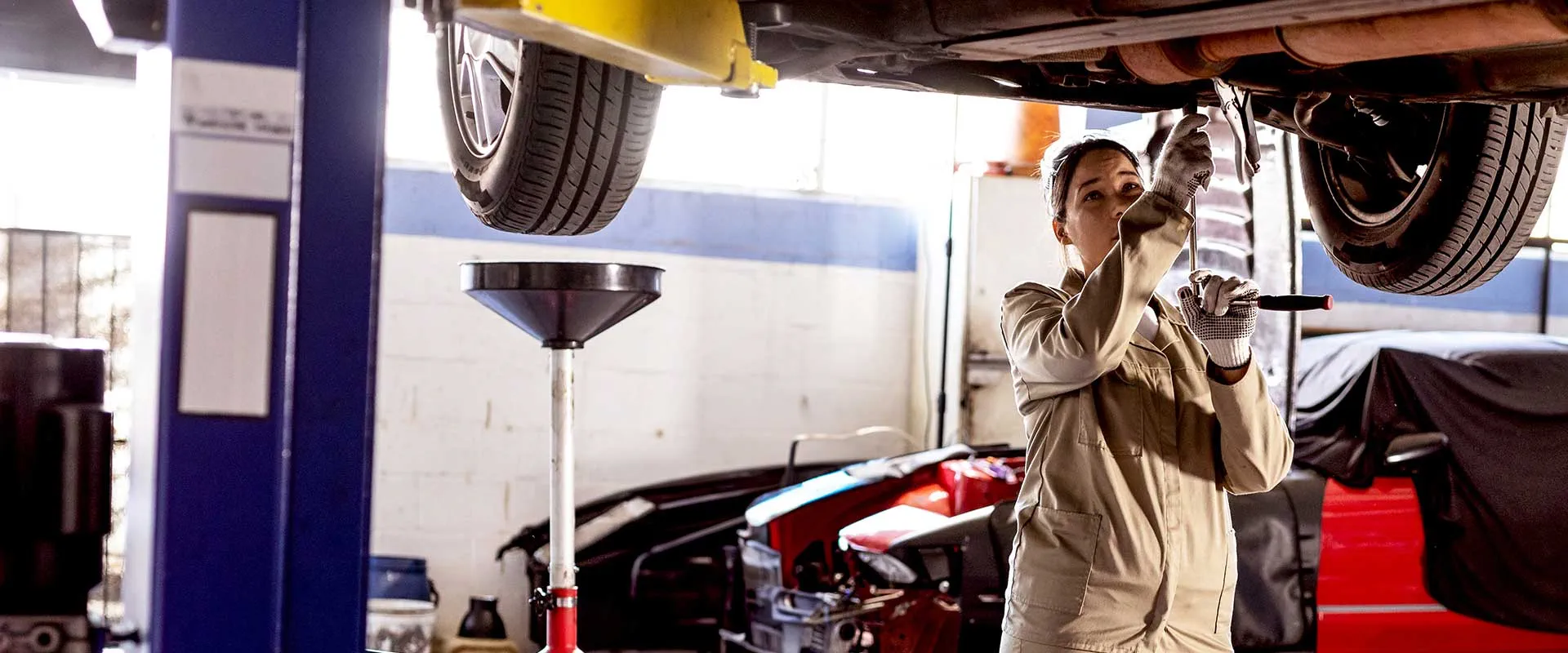  Automotive technician working under a raised vehicle in a modern wor