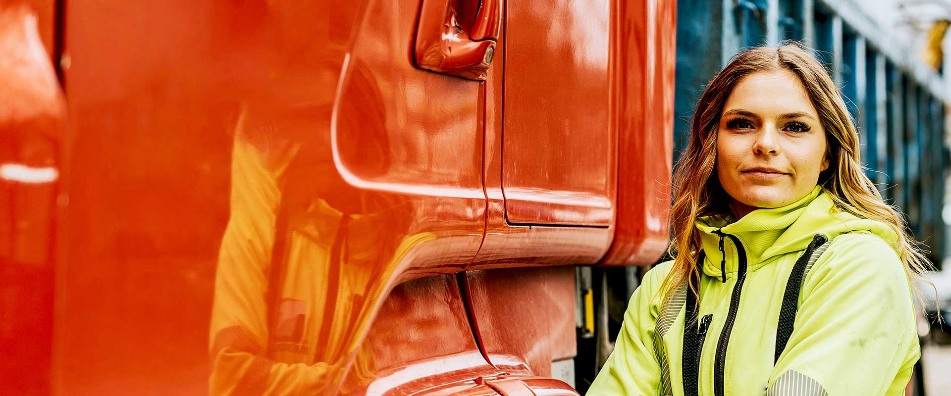  Construction worker standing beside red industrial vehicle
