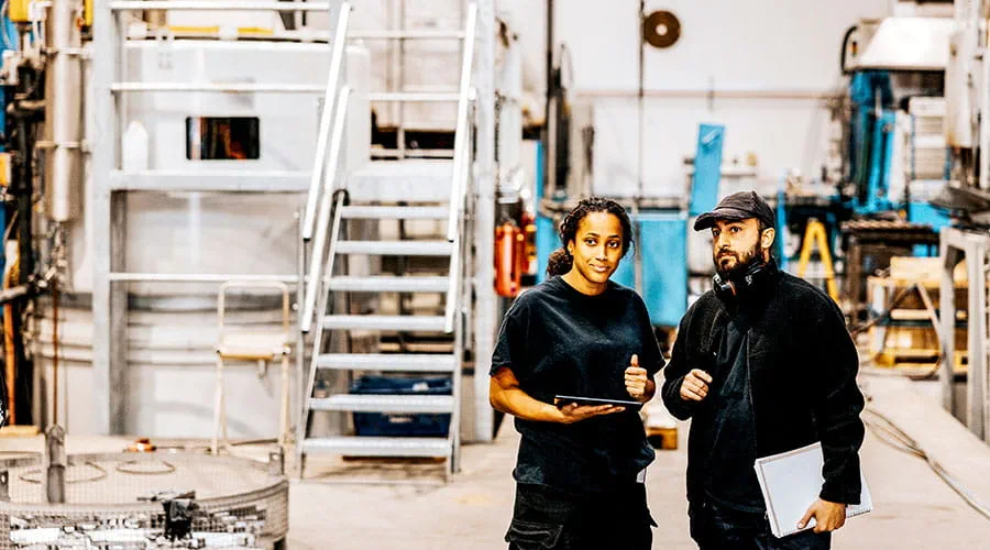 Two workers walking through industrial facility Two workers walking through industrial facility