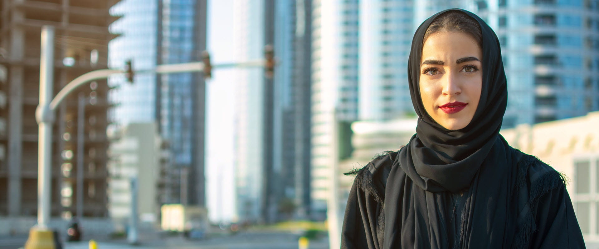 Person wearing black hijab standing on a city street.