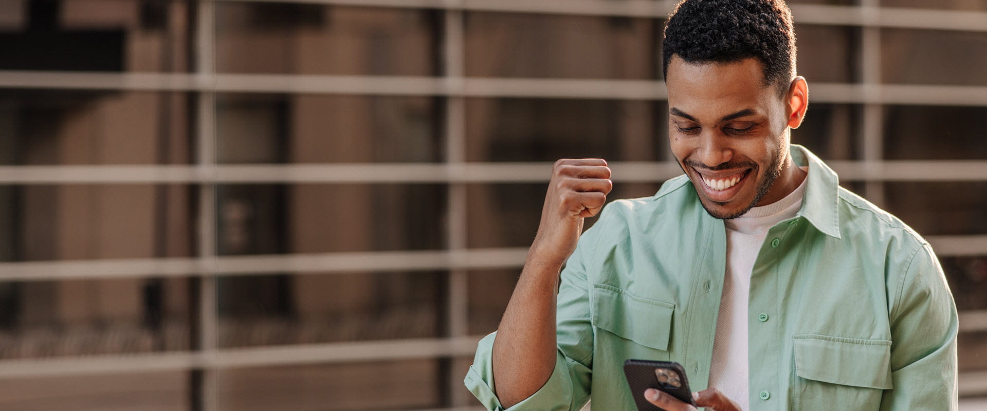 Person looking at phone doing a fist pump