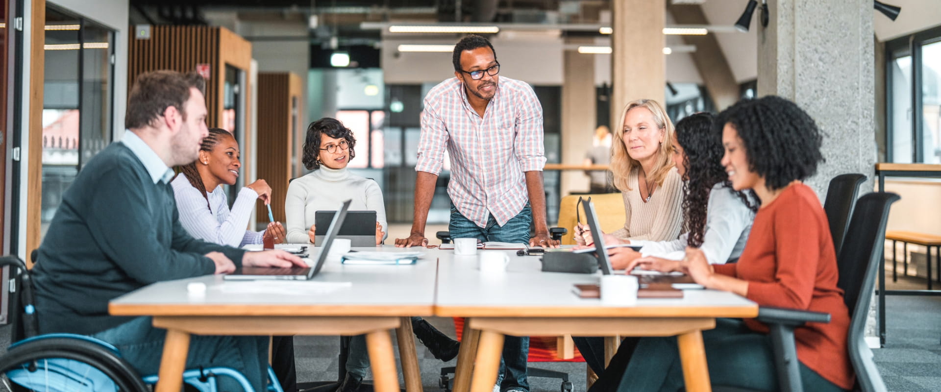 Work meeting being held in an office with a group of diverse people.