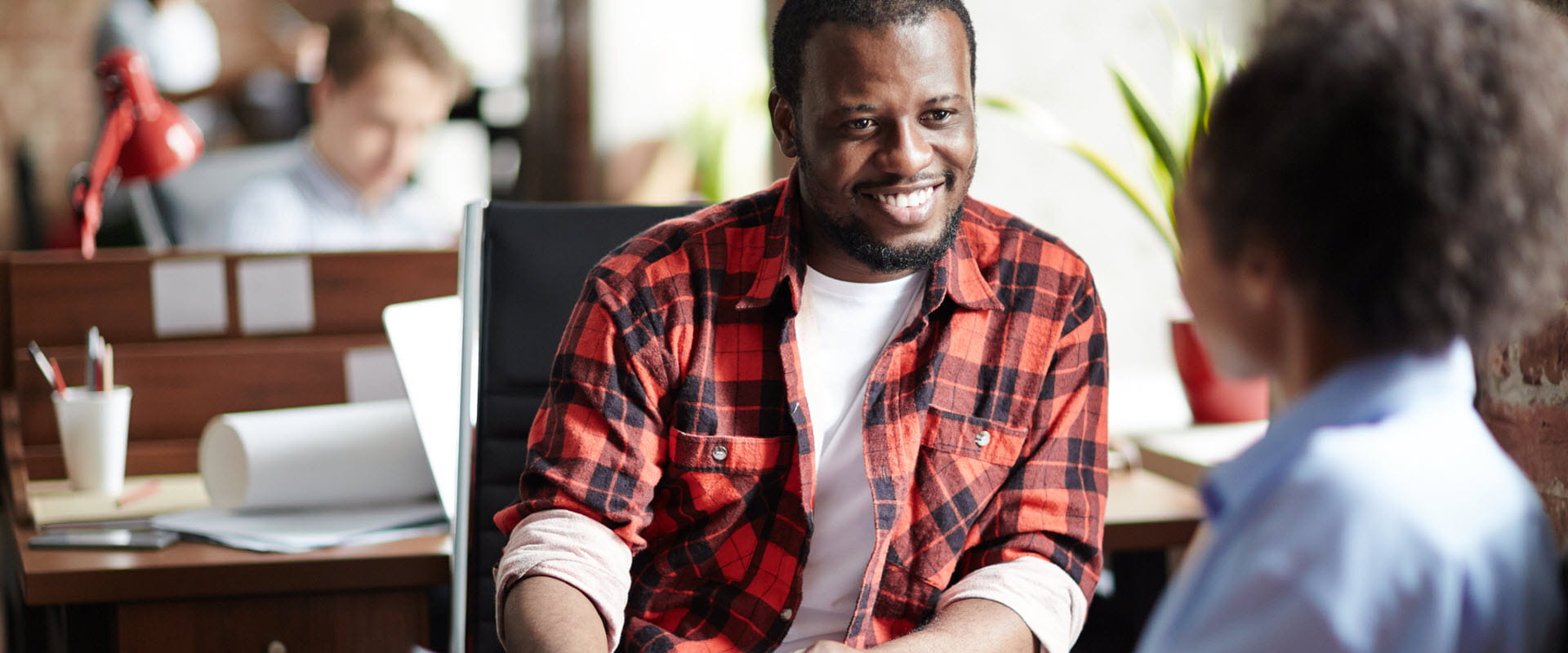 Smiling person in casual clothes conducting an interview with in an office.