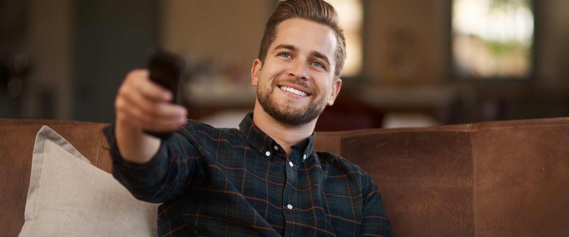 smiling man on couch with remote control smiling man on couch with remote control