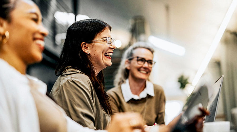  Group of colleagues laughing together in workplace