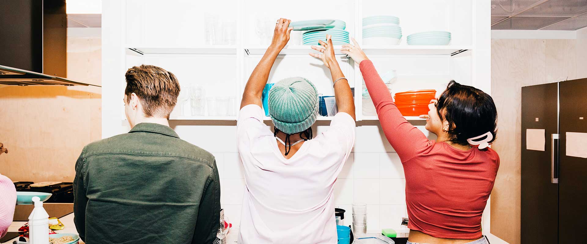 Un gruppo di lavoratori in cucina solleva insieme gli utensili in un momento di collaborazione. Un gruppo di lavoratori in cucina solleva insieme gli utensili in un momento di collaborazione.