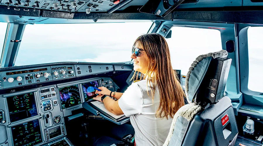 Il pilota aziona i comandi dell'aereo all'interno della cabina di pilotaggio. Il pilota aziona i comandi dell'aereo all'interno della cabina di pilotaggio.