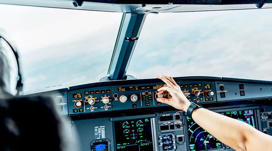Primo piano del pilota che regola i comandi nella cabina di pilotaggio dell'aereo. Primo piano del pilota che regola i comandi nella cabina di pilotaggio dell'aereo.