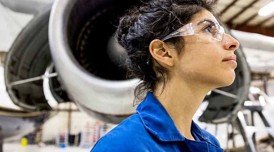 Tecnico che ispeziona il motore di un aereo nell'hangar. Tecnico che ispeziona il motore di un aereo nell'hangar.